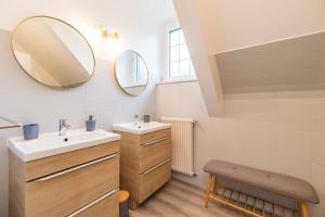 ein Badezimmer mit zwei Waschbecken und zwei Spiegeln in der Unterkunft Charmante maison la Tissanderie a Saint-Carreuc in Saint-Carreuc