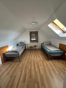 a room with two beds and a wooden floor at Mira Home 3 in Murg