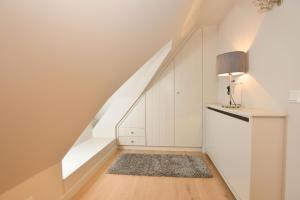 een kamer met witte muren en een trap met een kleed bij Witthüs 15 in Wenningstedt