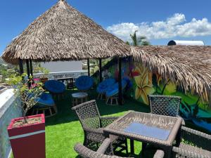 a patio with chairs and tables and a thatch roof at VaoVao Hotel in Nosy Be