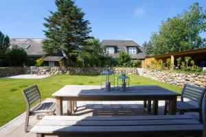 a wooden table and chairs in a yard at Ferienhaus Sylt Leev in Westerland