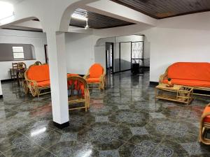a room with orange beds and chairs in it at VaoVao Hotel in Nosy Be