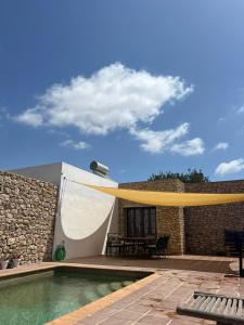 une terrasse avec une piscine à rétractation jaune dans l'établissement CT 354 AL - Faro's Casa Piedra - Agua Amarga - Cabo de Gata, à Almeria