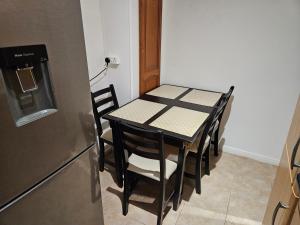 a table and chairs in a kitchen next to a refrigerator at Mitcham Junction - 2 Bed Apartment - Sleeps 6 in London