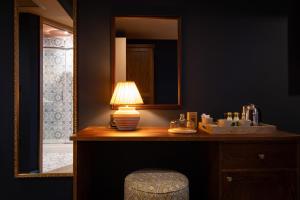 a bathroom with a vanity with a lamp and a mirror at The Royal Forest - A Heartwood Inn in Chingford