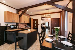 a kitchen and dining room with a table and chairs at Brzozowy Dwór Apartament I in Zamość