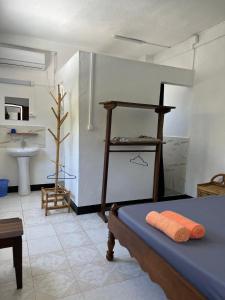 a room with a bed and a bathroom with a sink at VaoVao Hotel in Nosy Be