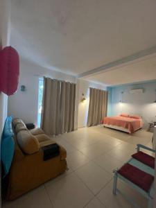 a living room with a couch and a bed at Las irmãs Cripsim in Rio de Janeiro