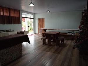 a living room with a table and a christmas tree at Hotel Pousada e Parada Colonial in Capitão Leônidas Marques