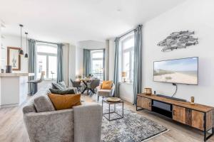 a living room with a couch and a tv at Exklusives Apartment Turmkoje im Herzen Westerlands in Westerland (Sylt)