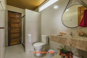 a bathroom with a toilet and a sink and a mirror at Casa na pedra em Serra Negra vista para montanha in Bezerros