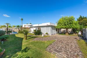 ein Haus mit einem Hof mit steinerner Einfahrt in der Unterkunft Villa Goccia by BarbarHouse in Torre dell'Orso