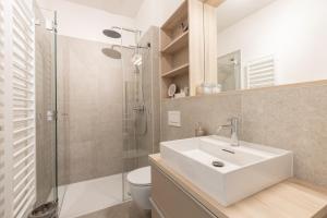 a bathroom with a sink and a shower and a toilet at NEU! Ferienwohnung Deck 2 - exklusives Apartment in zentraler Lage in Westerland (Sylt) +16 photos