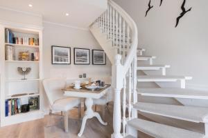 Un escalier blanc avec une table et une chaise dans l'établissement Ferienwohnung Luettje Moehl - Kleines Paradies am Wattenmeer in Keitum Sylt, à Keitum