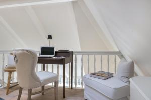 Cette chambre comprend un bureau avec un ordinateur portable et une chaise. dans l'établissement Ferienwohnung Luettje Moehl - Kleines Paradies am Wattenmeer in Keitum Sylt, à Keitum