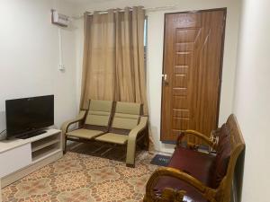 a living room with two chairs and a television at CuteHomes KB in Kota Belud