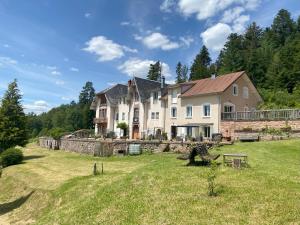 una grande casa su una collina con un cortile di Le Grimaubois a Hurbache