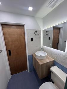 Un baño con lavabo, inodoro y espejo. en Apartamento en Porlamar, en Porlamar