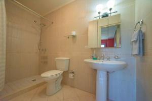a bathroom with a toilet and a sink and a shower at Palma Real 28 - 2-Bedroom Vacation Condo in Palm Beach, Aruba in Palm-Eagle Beach +3 photos