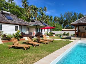 a backyard with chairs and a swimming pool at Fare MANTA in Afareaitu
