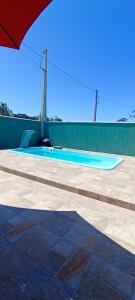 an empty swimming pool with a green wall at casa de praia ReJ 2 in Itapoa +12 photos