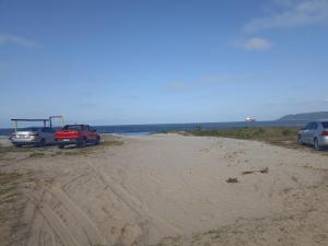 three cars parked on a sandy beach near the ocean at casa de praia ReJ 2 in Itapoa