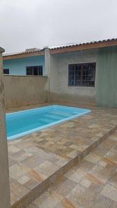 a swimming pool in front of a house at casa de praia ReJ 2 in Itapoa