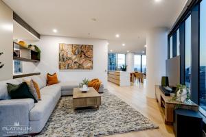Platinum Luxury Stays at Freshwater Place في ملبورن: غرفة معيشة مع أريكة وطاولة