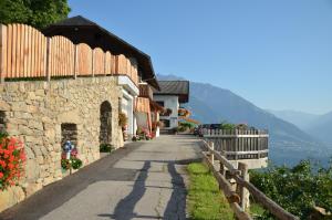 a street in a village with a stone building at Eichmannhof in Marlengo