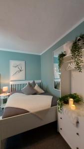 a bedroom with a bed and a blue wall at Maries bunte Villa in Bad Berleburg