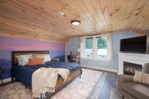 a bedroom with a blue bed and a fireplace at TuckAway Suites at East Branch in Intervale +53 photos