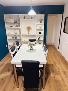 a dining room with a white table and chairs at Comfortable stay in Wembley in London