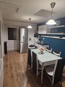 a kitchen with a table and chairs and a refrigerator at Comfortable stay in Wembley in London