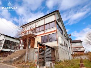 a building with a staircase in front of it at KONAYUKI Apartment in Myoko +28 photos