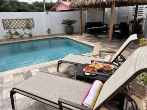 a table and chairs next to a swimming pool at Turibana Villa- 3 Bedroom, 2 Bathroom in Palm-Eagle Beach