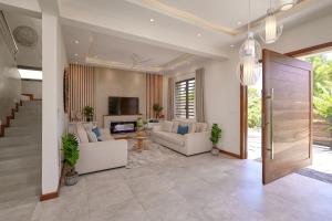 a living room with couches and a tv at Villa Cookie le Coquin, 3 chambre au centre de Grand Baie, jacuzzi in Grand Baie