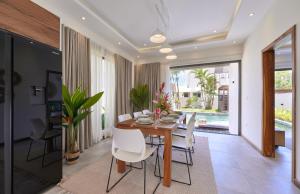 a dining room with a table and white chairs at Villa Cookie le Coquin, 3 chambre au centre de Grand Baie, jacuzzi in Grand Baie