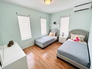 two beds in a bedroom with blue walls and wooden floors at Turibana Villa- 3 Bedroom, 2 Bathroom in Palm-Eagle Beach +19 photos