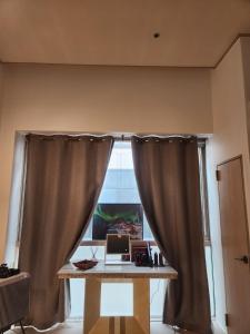 a window with a curtain and a desk with a laptop at Wooyeon in Seongnam