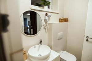 a white bathroom with a sink and a mirror at Anur Apartment in Ptuj +46 photos