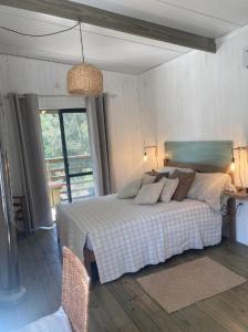 una camera da letto con un letto in una stanza con una finestra di RosMarino a La Pedrera