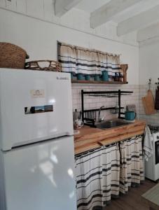 una cucina con un frigorifero bianco e un lavello di RosMarino a La Pedrera