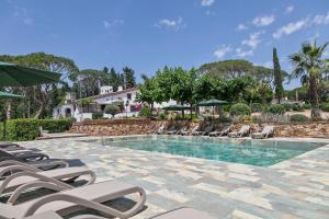 a swimming pool with lounge chairs and a resort at Masia Luxmarspa in Barcelona