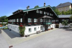 a large black and white building with flowers on it at Familienresort Reslwirt in Flachau