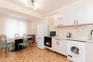 a kitchen with a washer and dryer and a table at ERA RENT Apartments in Chişinău