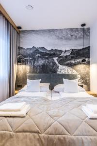 a bedroom with a large bed with a wall mural at Apartamenty Tatra Lux in Bukowina Tatrzańska