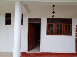 an open door of a white building with at Polhena Palms in Polhena