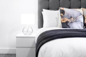 Un dormitorio con una cama con un edredón blanco y negro. en Two Bedroom Apartment - Balcony - Secure Parking - Smart TV - Wifi - Netflix - 3MC, en Birmingham 27 fotos más