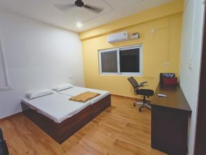 a room with a bed and a desk and a chair at AETAS Hospitality, Port Blair in Aberdeen