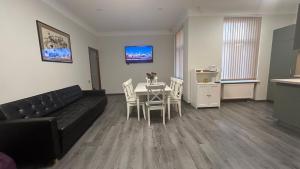 een woonkamer met een bank en een tafel met stoelen bij LAIMA RENDEZVOUS APARTMENTS in Rīga